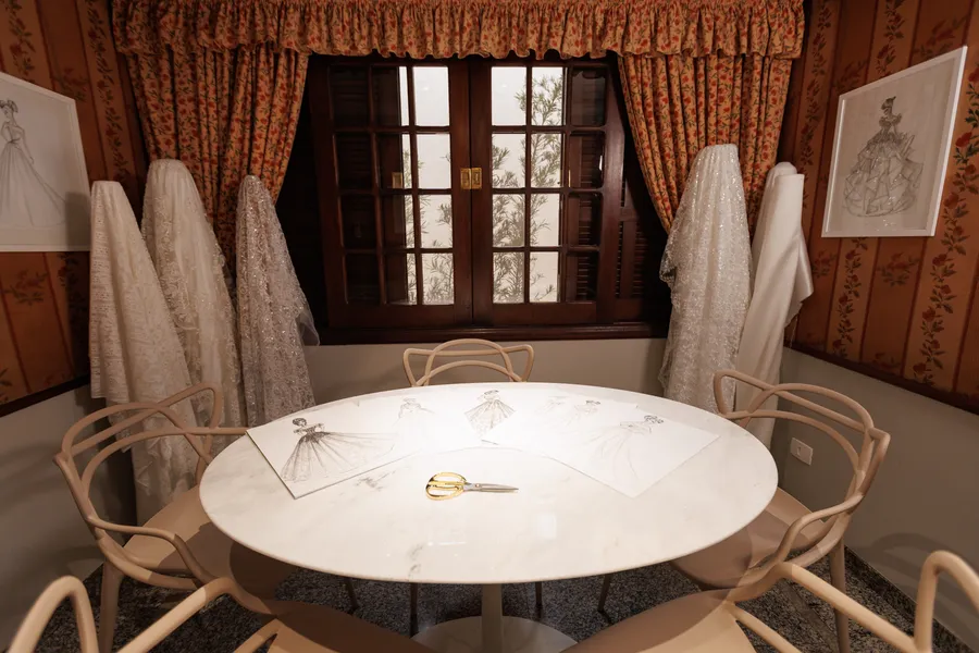 A sala de croquis, com a mesa de mármore e as cadeiras claras.